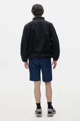 Campera estilo olímpica con cierre frontal, corte oversized y elástico en la cintura. Diseño con bloques de color negro y beige.