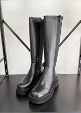 Botas altas de cuero vegano color negro, con caña alta hasta la rodilla y suela track.