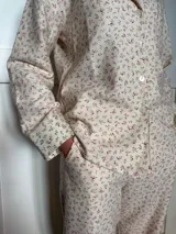 Pijama de viyela de algodón estampada con hojas rojas, compuesto por una camisa abotonada y un pantalón con elástico en la cintura y bolsillos laterales.