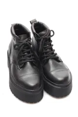 Bota de cuero negro estilo borcego corto con plataforma baja y cierre lateral.