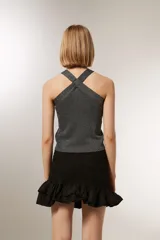 Top cropped gris metalizado con cuello halter y detalle de studs.