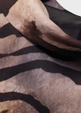 Vestido corto de manga larga con cuello alto y estampado de cebra en tonos marrones y negros.