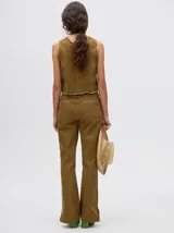 Pantalón de jean azul de tiro alto y corte oxford con apliques metálicos en bolsillos y laterales.