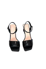 Sandalias de tacón bloque color negro charol, con tira delgada sobre los dedos y pulsera al tobillo con hebilla.