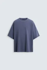 Camiseta azul de corte holgado, cuello redondo y manga corta. Tiene un efecto lavado que le da una apariencia única.
