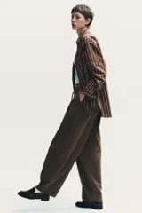 Pantalón cargo negro de corte amplio con cintura ajustable con cordón, bolsillos laterales y bolsillos tipo parche en las piernas.