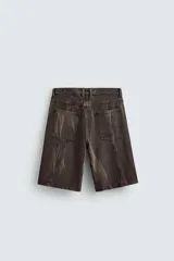 Bermuda de jean color marrón oscuro con efecto lavado, corte amplio, cinco bolsillos y cierre frontal con cremallera y botón.