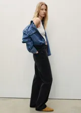 Pantalón de jean negro de corte recto, tiro alto y cinco bolsillos.