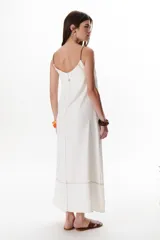 Vestido largo color crudo con breteles finos y costuras a la vista en color azul.