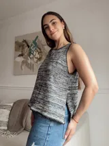 Musculosa de punto con diseño de rayas horizontales en tonos gris, azul y negro. Tiene cuello redondo y sisas amplias. El corte es holgado y presenta aberturas laterales en el ruedo.