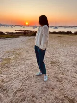 Sweater tejido en boucle color crema, de corte holgado y mangas largas.