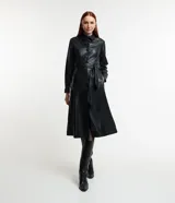 Vestido midi negro de cuero sintético, corte chemise con cuello camisero, manga larga con puños abotonados, cierre frontal con botones y cinturón con lazo.
