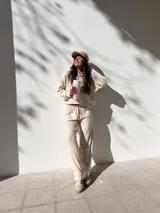 Conjunto deportivo color beige, compuesto por un buzo corto de tela waffle y un pantalón de corte recto con cintura elástica.