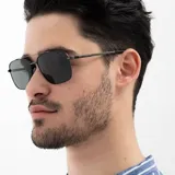 Lentes de sol INVU unisex, con montura metálica negra, forma aviador y lentes polarizadas grises.