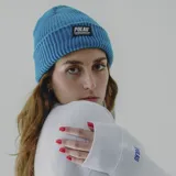 Gorro de lana blanco con etiqueta negra con el logo de la marca Pulau.
