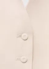 Chaleco color crema con cuello halter y peplum. Cierre frontal con botones.