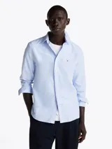 Camisa celeste con rayas verticales, de corte regular, cuello abotonado, mangas largas con puños abotonados y logo de la marca bordado en el pecho.