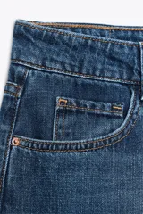 Pantalón de jean azul oscuro, de corte recto y tiro medio, con cinco bolsillos, efecto lavado y cierre frontal con cremallera y botón.