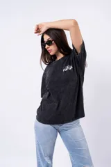 Remera oversize de algodón con efecto acid wash negro/gris, cuello redondo y manga corta. Estampado frontal pequeño con la palabra "Culture" en blanco.