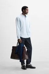 Camisa azul marino de algodón con textura jacquard, corte relaxed fit, cuello solapa, manga larga con puños abotonados y cierre frontal con botones.