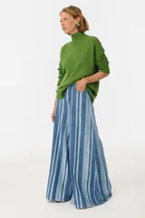 Pantalón de jean azul con rayas verticales blancas, corte amplio y cintura alta.