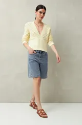 Bermuda de jean azul de corte clásico y largo a la rodilla.