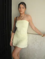 Vestido corto color amarillo pálido, strapless, con falda de volados.