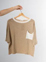 Remera tejida en hilo italiano color beige, con cuello a la base y bolsillo frontal. De caída relajada y silueta amplia.