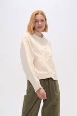 Chaqueta color crema de algodón con cuello mao, cierre frontal con botones, bolsillos laterales y mangas largas.