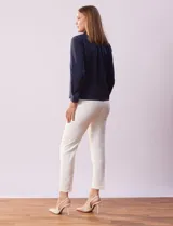 Camisa blanca de gasa, marca Sioni, con cuello con solapa, abertura central con botones y mangas largas con puño y botón.