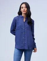 Camisa en lyocell azul, con cuello con solapa, abertura central con botones y bolsillos en la parte delantera.