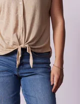 Blusa de modal con estampado de hojas en tonos azulados, escote en V con botones y ruedo anudado.