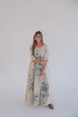 Vestido largo color beige con estampado de flores azules, corte amplio, escote en V y mangas 3/4.