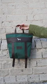 Mochila pequeña color borgoña con detalles en cuero marrón, asa de mano y correas ajustables.