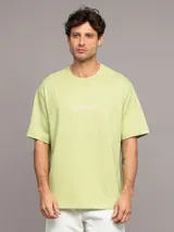 Remera verde claro de algodón con cuello redondo y logo de Calvin Klein estampado en el pecho.