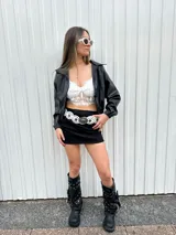 Campera bomber negra de cuero sintético con cuello clásico, cierre frontal y mangas largas con puños elásticos.