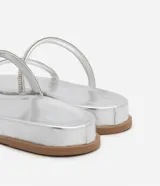 Sandalias plateadas planas con dos tiras finas de strass y puntera redonda.