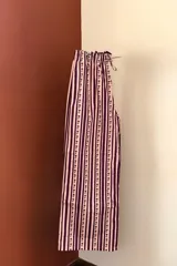 Pantalón de algodón con rayas verticales color borgoña y rosa, y elástico en la cintura.