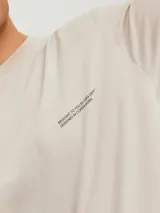 Camiseta color beige de manga corta y cuello redondo con calce relajado.