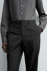 Pantalón de vestir negro de lana, corte recto, con bolsillos laterales y traseros de ojal con botón.