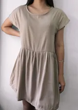 Vestido corto beige con corte imperio y mangas cortas, diseño suelto y cómodo.