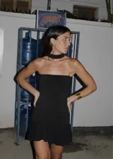 Vestido corto negro strapless al cuerpo con tablitas y cierre en la espalda.
