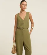Pantalón negro de corte zanahoria, con cintura elástica, adorno metalizado en la cintura y bolsillos laterales.