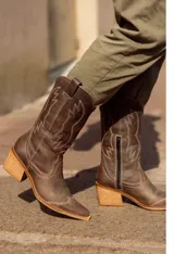Bota texana de cuero color marrón, con caña media, punta fina y taco de madera.