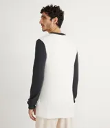 Suéter de punto blanco con cuello y mangas largas en color negro.
