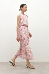 Falda midi de corte evasé con estampado paisley en tonos rosa, naranja y verde sobre fondo blanco.