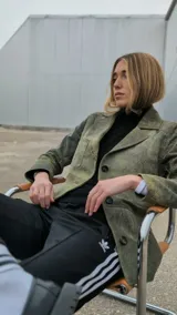 Blazer azul marino gastado de cuero ovino, con solapas de muesca, cierre frontal con botones, bolsillo de parche en el pecho y bolsillos con solapa en la parte inferior.
