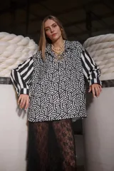 Camisa holgada estampada en blanco y negro con diseño geométrico y mangas con rayas verticales.