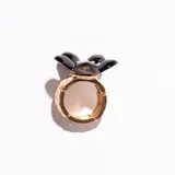 Anillo dorado con aplique de flor negra.