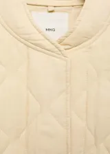 Chaqueta acolchada color verde militar con cuello perkins, cierre frontal con botones, dos bolsillos laterales y detalle fruncido en el bajo. Estilo bomber.